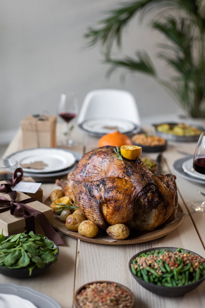 A beautifully set Thanksgiving dinner table featuring a roasted turkey and side dishes.