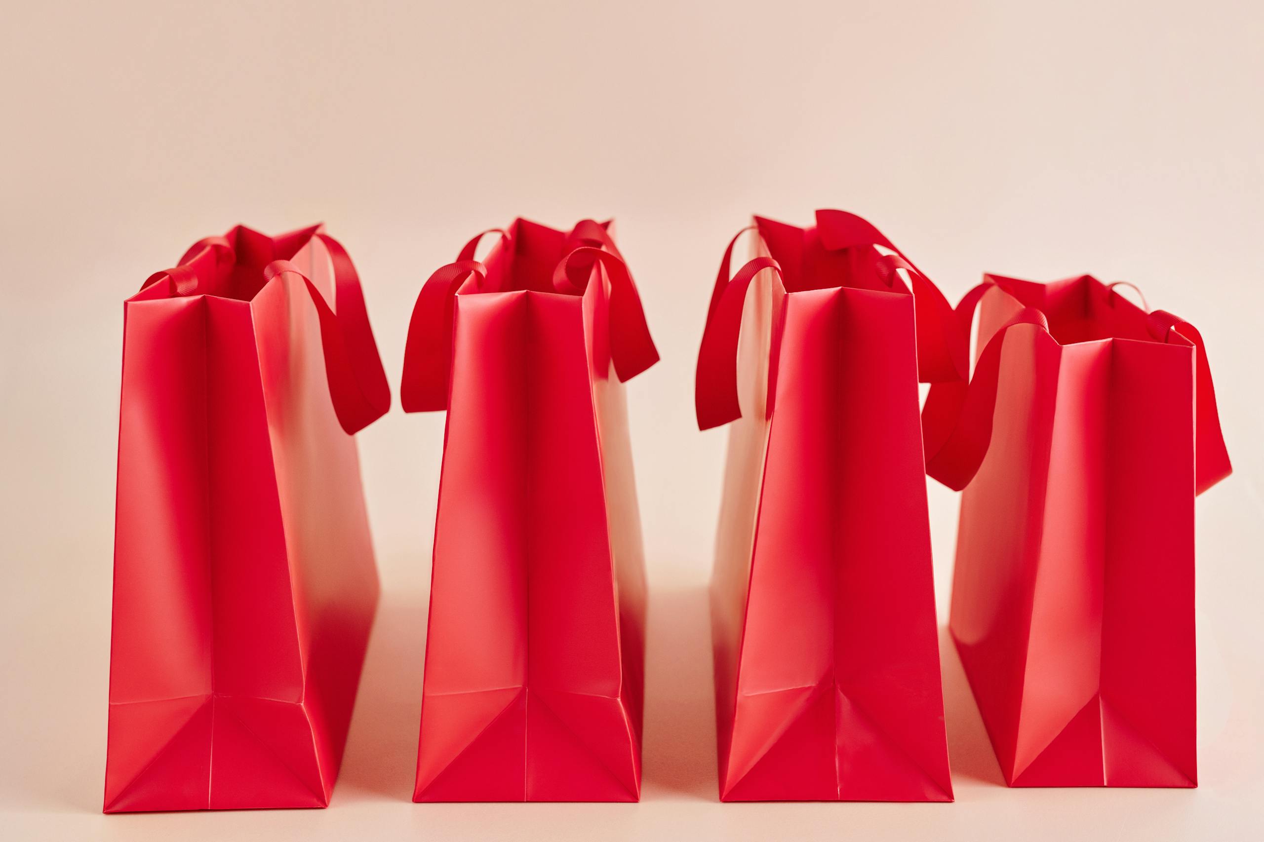 A row of vibrant red shopping bags for retail or gift concepts.
